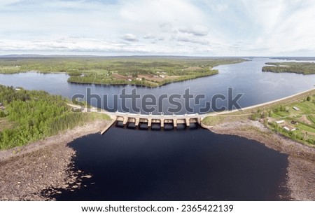 Hydro power plant in Finland. Making green energy. Dam on one of the thousands lakes of Finland. Water reservoir in front of the power plant's dam. Early summer day in Scandinavia.