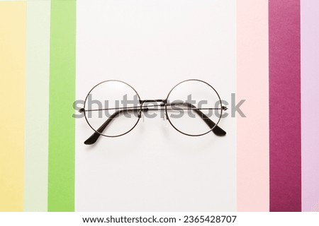 Eyeglasses with metal round rim is on abstract background.