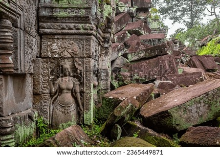 Moss covered green stone carving temple wall design and bricks at the Ta Prohm Tomb Raider Temple complex in Angkor Wat historical park Seim Reap, Cambodia Royalty-Free Stock Photo #2365449871