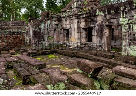 Moss covered green stone temple exterior and bricks at the Ta Prohm Tomb Raider Temple complex wall in Angkor Wat historical site park, Seim Reap, Cambodia Royalty-Free Stock Photo #2365449919
