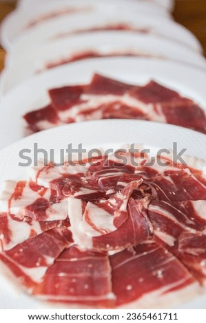 Acorn-fed iberian ham on plates. Selective focus Royalty-Free Stock Photo #2365461711