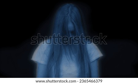 Medium shot of a glowing female, woman figure, ghost, poltergeist standing with her head down, hair covering her face on a black background.