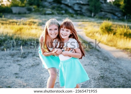 Outdoor portrait of young beautiful mother with her cute little daughter
