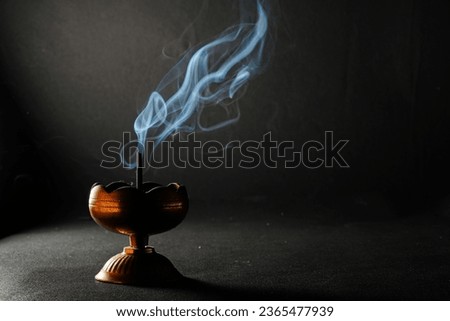 Agarbathi stand and smoke in a dark backgrounds text space Royalty-Free Stock Photo #2365477939
