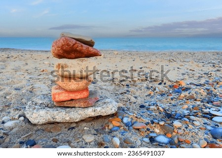 Pebble stone pyramid for yoga relaxation on sea beach. Dream and Idylic on beach sea. Relaxed spiritually at pebble tower. Zen stones on Pebble beach. Relax, Harmony and Positive Mind on seashore.