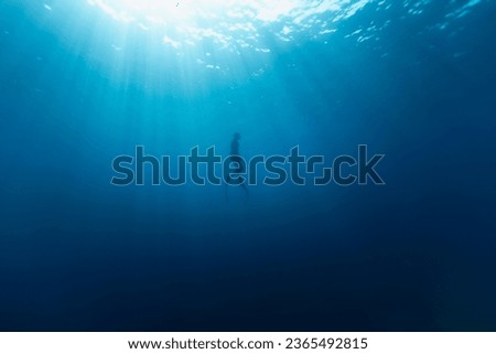 Freediver Swimming in Deep Sea With Sunrays. Young Man DIver Eploring Sea Life. Royalty-Free Stock Photo #2365492815