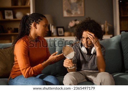 Mother and son talking about teenage acne problem at home Royalty-Free Stock Photo #2365497179
