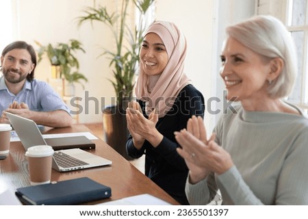 Multicultural businesspeople clap hands finish meeting, different culture and age workers greet coach start seminar, cheering applauding successful employee, reaction after motivational speech concept Royalty-Free Stock Photo #2365501397