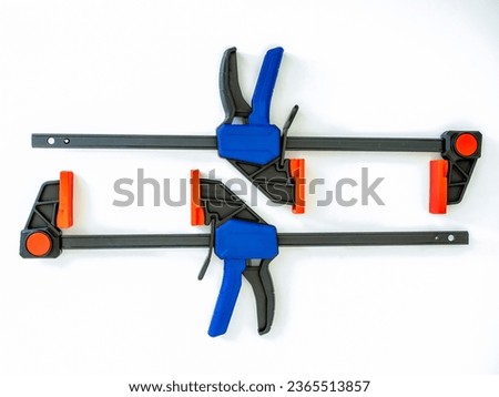 pair of lightweight speed quick release clamps used in woodworking and engineering isolated on a white background Royalty-Free Stock Photo #2365513857