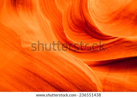 Background of vibrant orange swirling sandstone rocks inside of Upper Antelope Canyon in Page, Arizona.