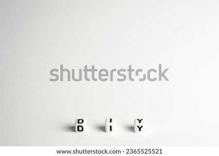 diy word or concept made by white letter cubes on white and gray background, do it yourself abbreviation
