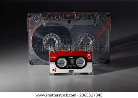 vintage analog audio compact and micro cassette with transparent case and visible tape from the 90s