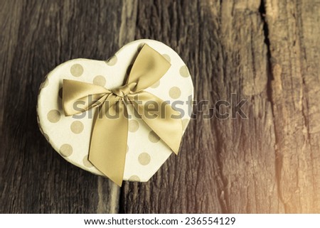 Heart shaped Valentines Day gift box on wood.
