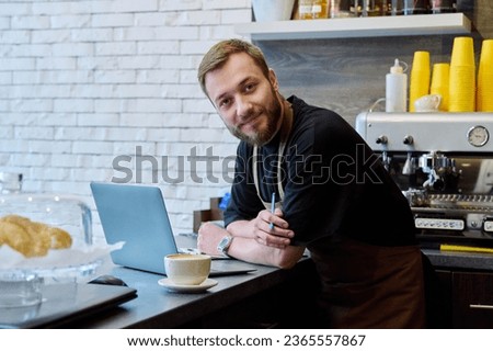 Owner coffee shop worker young male with laptop on the counter Royalty-Free Stock Photo #2365557867