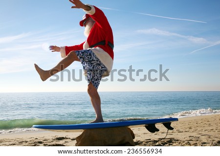 Santa Claus practices his Surfing Skills on his Surf Board on the beach, before he goes into the ocean. Santa Loves the Beach when on vacation from delivering gifts to good boys and girls at christmas