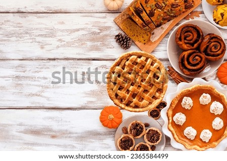 Autumn desserts side border. Table scene with an assortment of traditional fall sweet treats. Above view over a white wood background. Copy space. Royalty-Free Stock Photo #2365584499