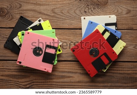 Stack of colored Retro 80s floppy disks on wooden background. Vintage technology. Top view.