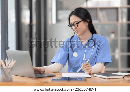 Medical doctor working with laptop and stethoscope at desk in hospital, Asian female doctor, Healthcare and medical service concept. Royalty-Free Stock Photo #2365594891