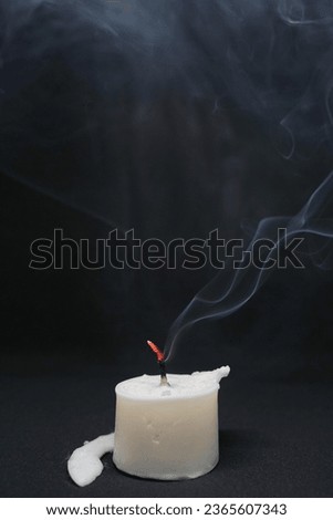 a candle burnt out smoke everywhere with dark black background