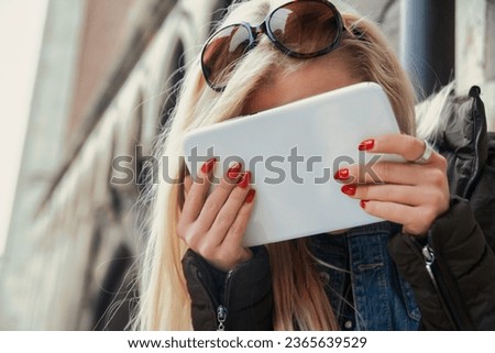 In Europe without prior planning, a young blonde tourist turns to her tablet for support. The internet provides her with maps and answers, allowing her to relax and enjoy her real-world experiences