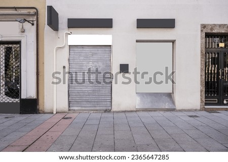 Front facades of a commercial premises with metal mesh closure Royalty-Free Stock Photo #2365647285