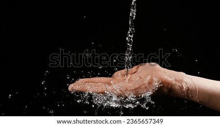 Hands of Woman and Water against Black Background