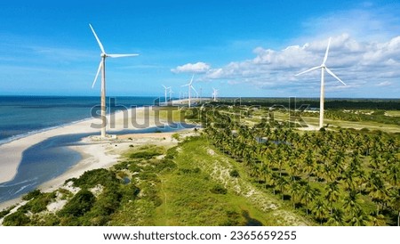 Northeast Brazil. Aeolian turbine at Beach at Ceara state. Beach with sand dunes and desert landscape. Power generation. Green energy. Wind farm field. Royalty-Free Stock Photo #2365659255