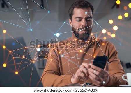 Handsome businessman working on laptop at office workplace in background. Using phone to read text, and send messages. Concept of business education and network connection.