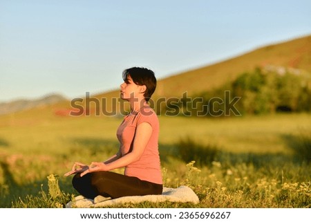 young woman in pink t-shirt doing yoga