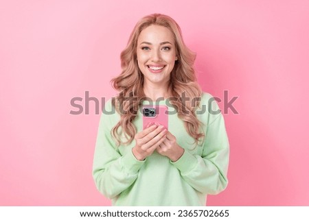 Portrait of cheerful young blogging lady holding case apple iphone device modern interface update isolated on pink color background