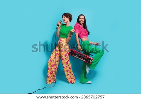 Full body photo of crazy girls jazz singers vocal music creators hold microphone hold cassette player isolated on blue color background