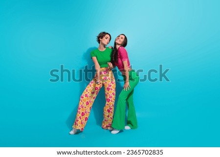 Full body length photo of two coquette flirting girls friendship posing stunning models romantic night isolated on blue color background Royalty-Free Stock Photo #2365702835