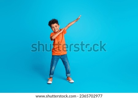 Full length body cadre of small boy kindergarten moves dab sign have fun dab demonstration dancing isolated on blue color background