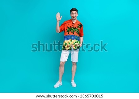 Full length photo of funny optimistic man with stylish hairdo dressed print shirt waving palm say hello isolated on blue color background Royalty-Free Stock Photo #2365703015