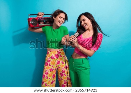 Photo of sweet adorable ladies wear colorful clothes enjoying boom box music singing mic dancing isolated blue color background