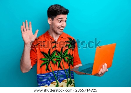 Photo of positive friendly man waving palm greetings video conference online laptop tour agency traveling isolated on blue color background