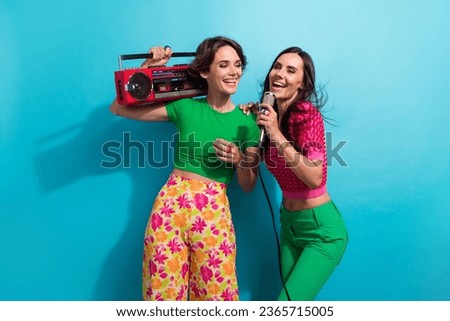 Photo of adorable pretty ladies wear colorful clothes singing boom box karaoke isolated blue color background