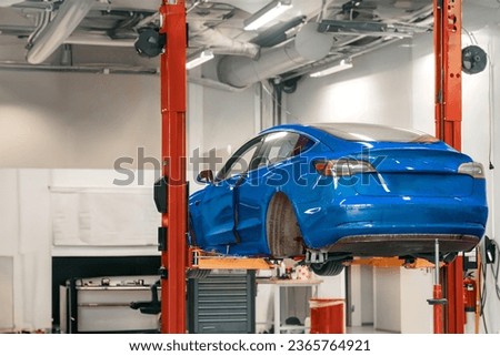 Removed wheel. Electric vehicle maintenance at a Professional Workshop. Repairing the EV transport. The car lifted in the auto service shop. The rear hub of a car without a wheel. Royalty-Free Stock Photo #2365764921