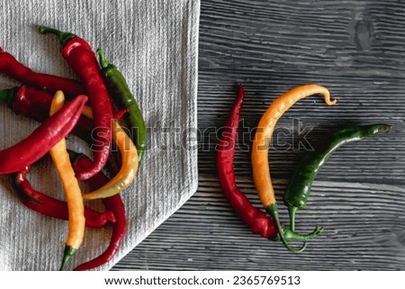 red, green and yellow hot pepper on a gray background. bright colors of summer vegetables.
