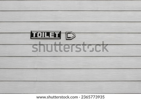 public toilet sign on wooden wall