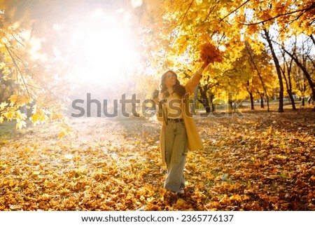 
Smiling woman in a light coat with a retro camera spends time having fun in the autumn forest. Happy mood, leisure time. Lifestyle concept. Royalty-Free Stock Photo #2365776137