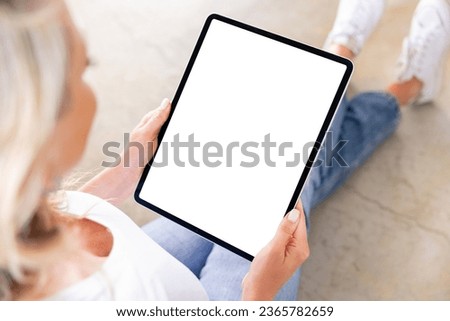 Woman holding tablet computer vertically in hands