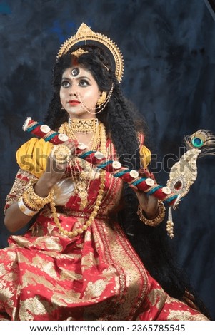 Portrait of beautiful Indian girl of Durga Idol Agomoni Concept Indoor Photo wearing traditional Indian saree, gold jewellery, and bangles. Maa Durga agomoni shoot concept.Indian culture durga puja.