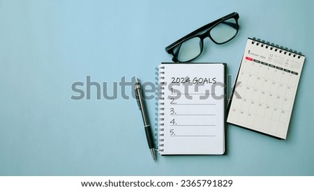 2024 New Year goal, plan, and action concepts. 2024 goals Text on Note Pad with calendar, glasses on the table.New Year's resolutions plan.Happy New Year theme, top view, copy space. Royalty-Free Stock Photo #2365791829
