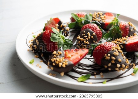 Strawberries dipped in dark chocolate and coated with toasted almonds. Royalty-Free Stock Photo #2365795805