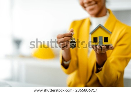 African American female real estate agent delivers house model to client mortgage loan contract Make a contract to buy and sell a house. and home insurance contract home mortgage loan concept