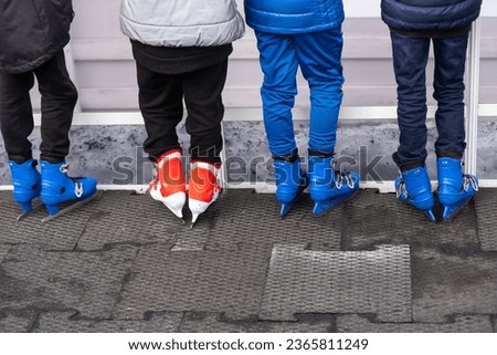 Close-up of family of three wearing skates standing on skating rink they going to skate.