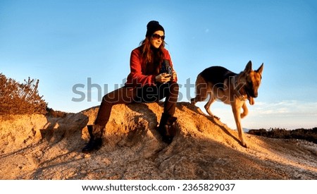 Female photographer capturing her dog with a 6x6 vintage camera in a landscape with a clear sky. With Copy space