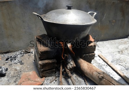 close up of iron pots on top of a traditional Indonesian stove. stove lit with wood as fuel. traditional cooking on a farm in Indonesia. concept of typical gastronomy.