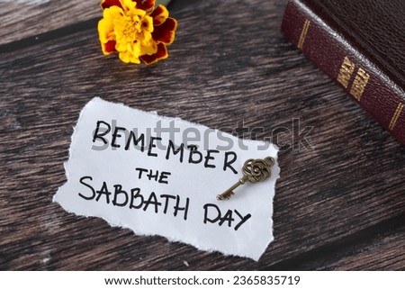 Remember the Sabbath Day, handwritten quote with ancient key, holy bible book, and flower on wooden background. Biblical rest, Christian obedience to fourth commandment, blessing from God. Royalty-Free Stock Photo #2365835719